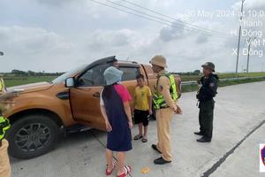 Để bé trai ngồi trên thùng xe bán tải chạy băng băng trên cao tốc