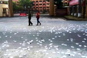 Hai thanh niên rải trắng phao thi giả trước cổng trường